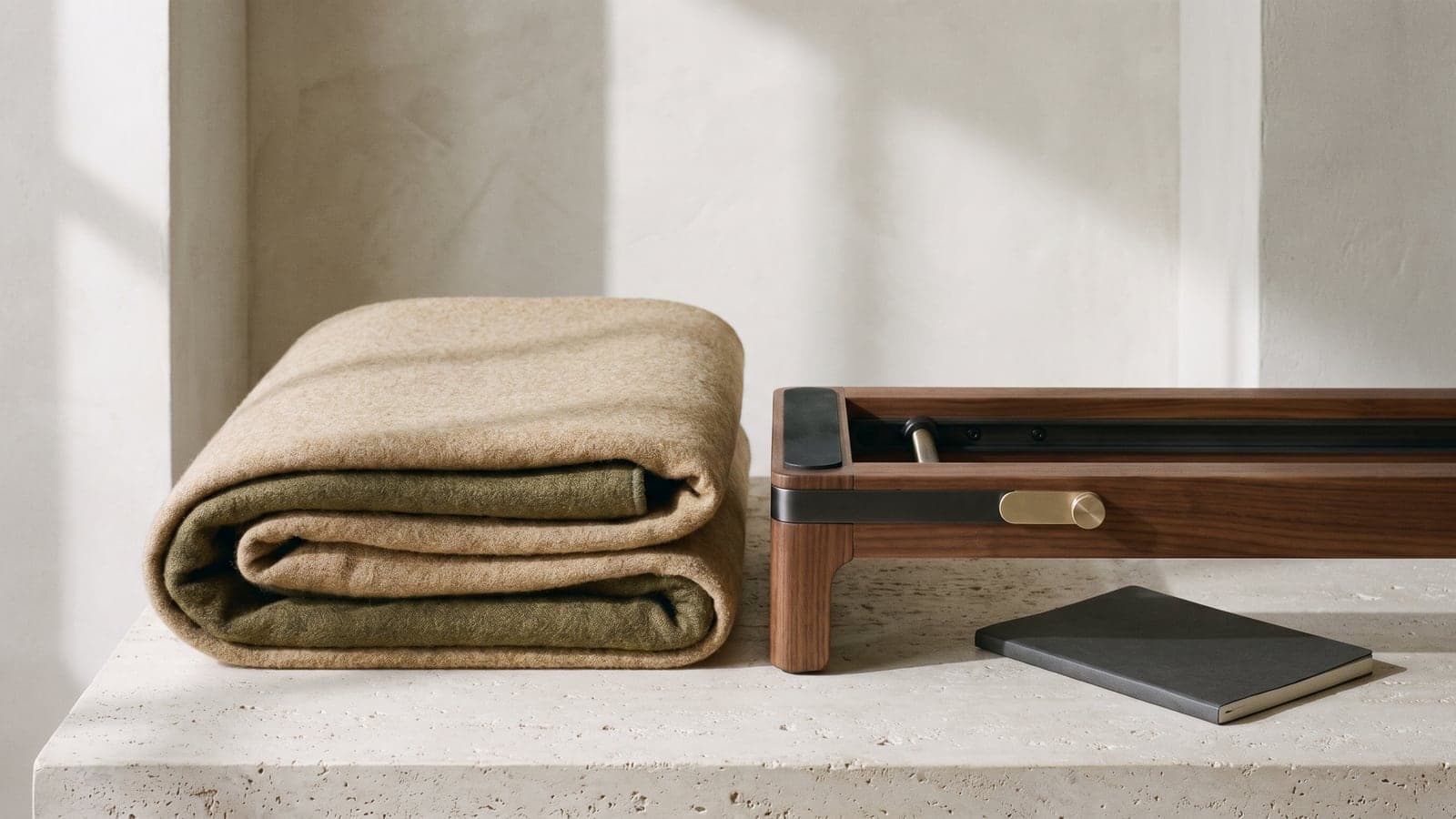 Folded neutral mat beside an unbranded dark metal equipment rail in soft side light