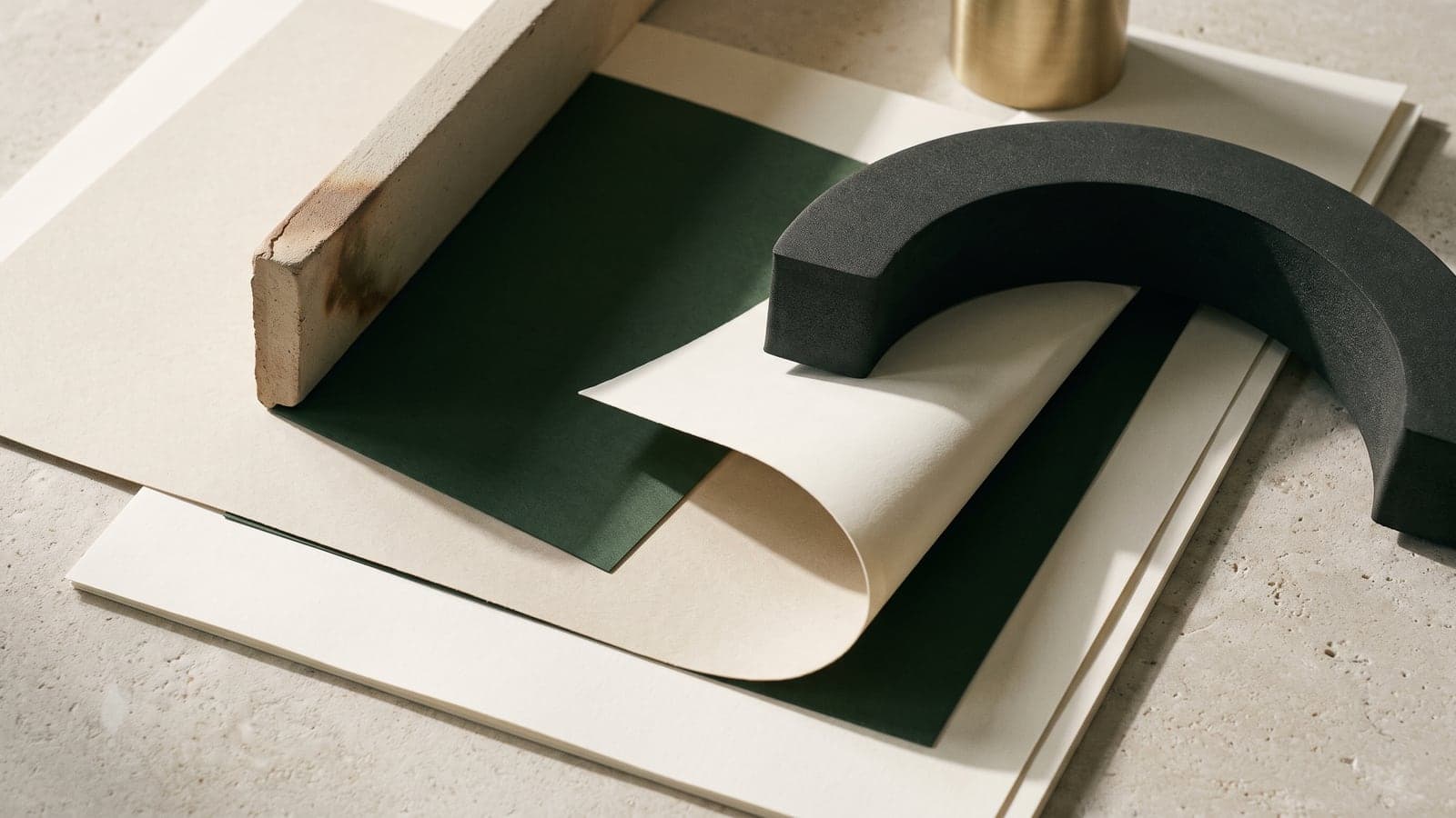 Layered blank ivory sheets with a charcoal arc, clay edge, and forest shadow