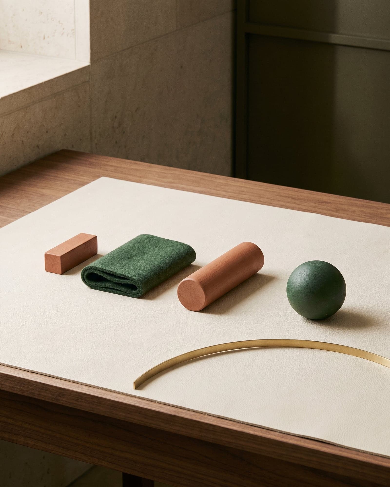 Clay and forest green modules arranged in a measured sequence across walnut